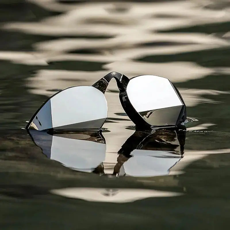 Black Magic Mirror Silver swim goggles floating on water