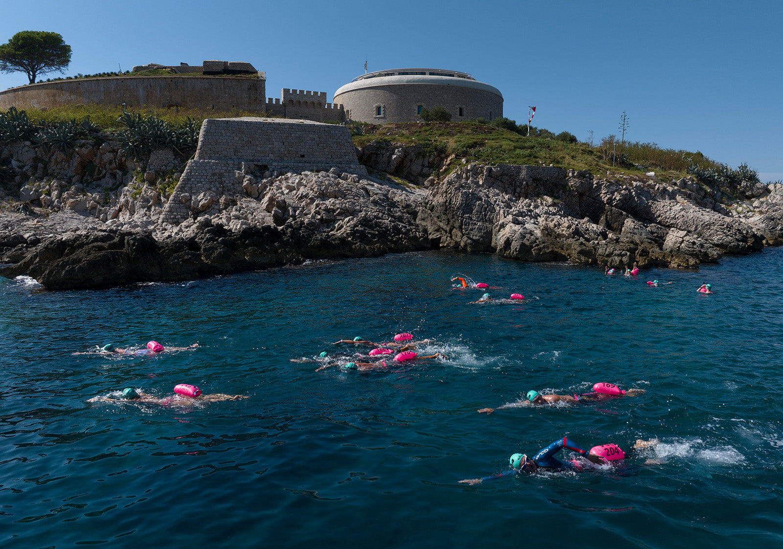 Swimmers navigate around a landmark in montenegro