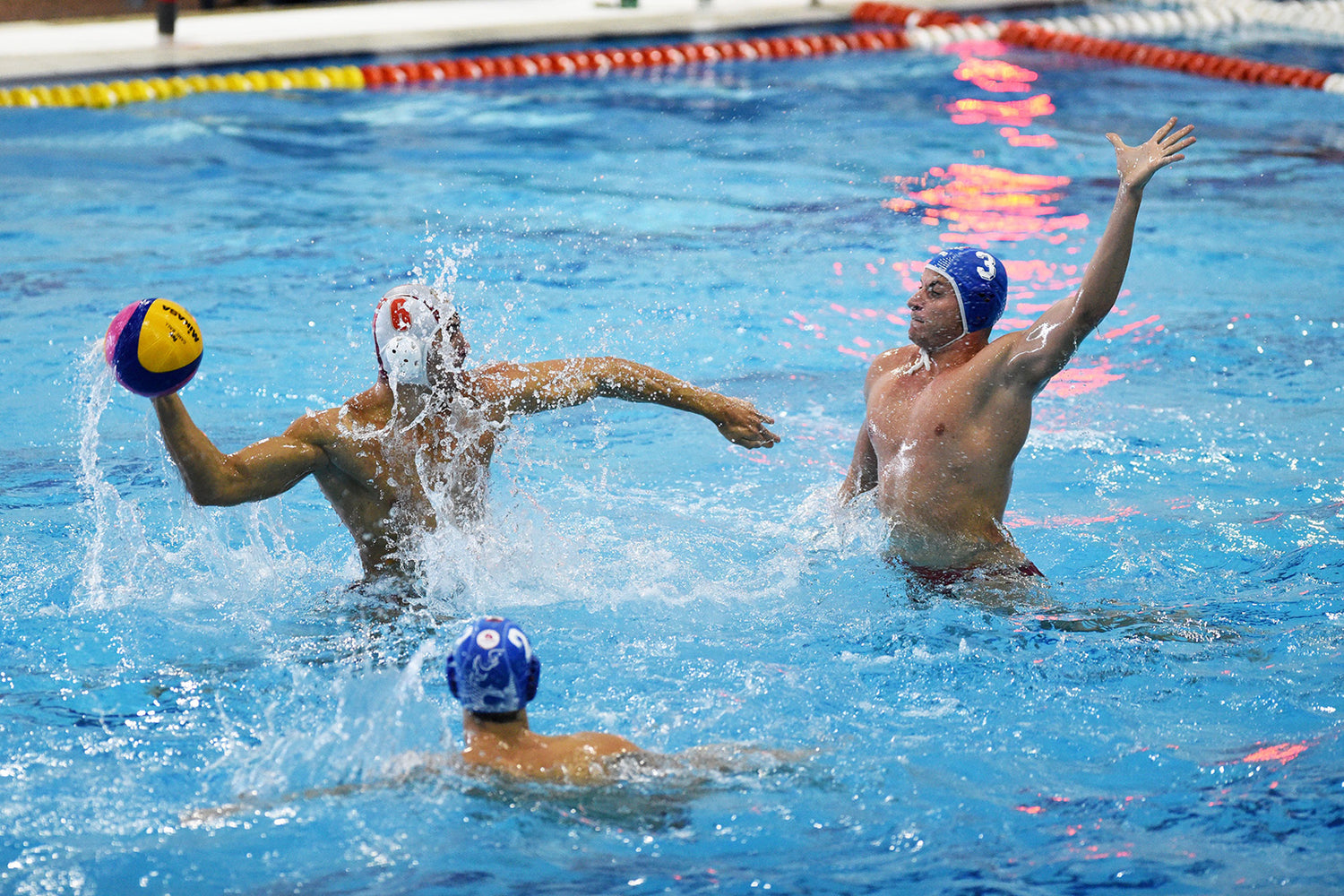 3 men playing water polo