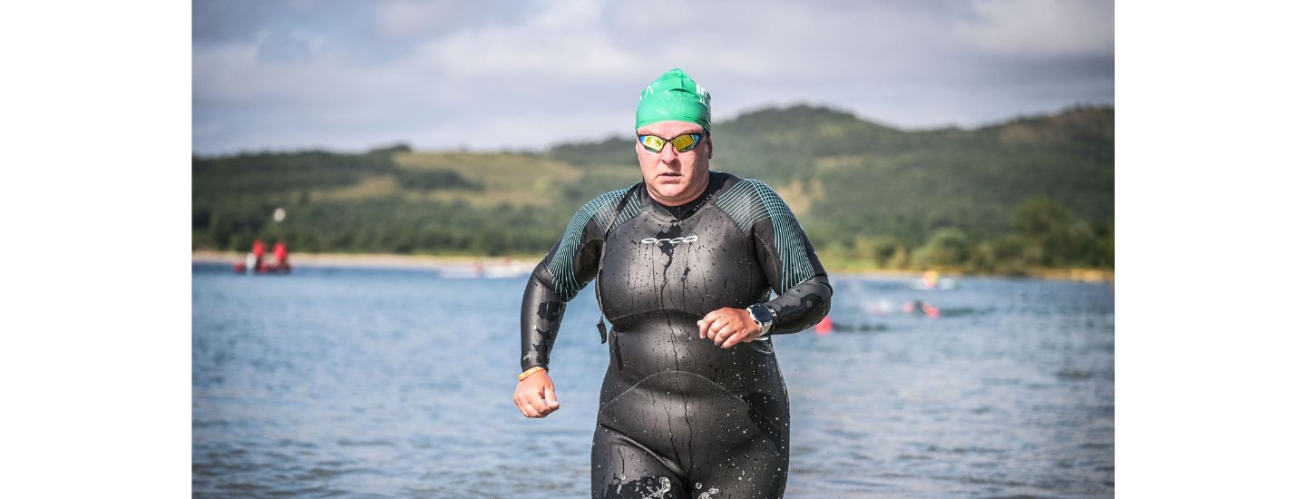 Dr. Leia Kane competing in a triathlon running out of the water.