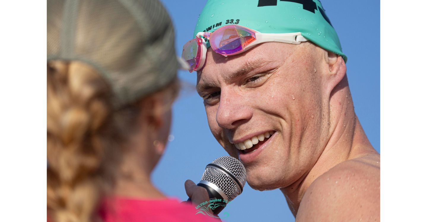 Niklas talking into a microphone after completing a swim