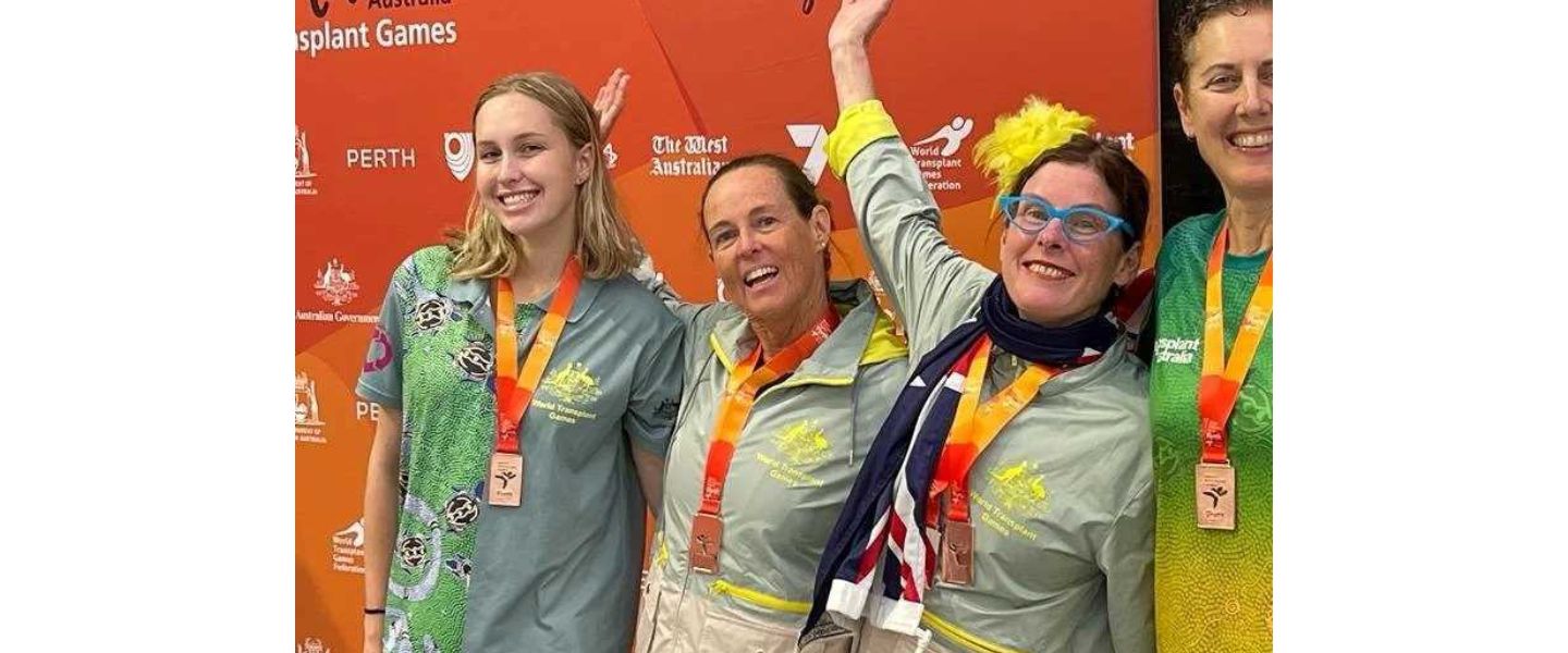 Sue smiling alongside her fellow teammates and transplant athletes