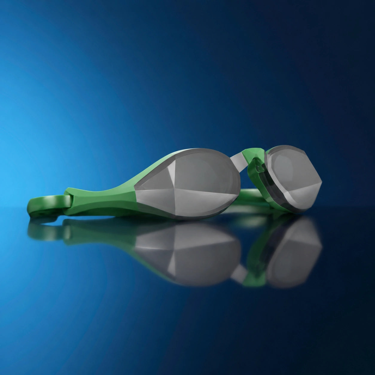 Green and silver swim goggles resting on a reflective blue surface against a dark blue gradient background.